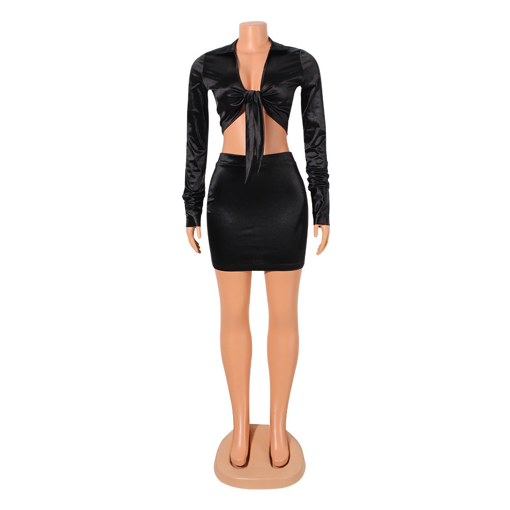 Black bow-front top and matching mini skirt displayed on a mannequin, front view.