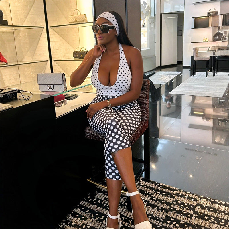 Adult model seated in the black-and-white polka-dot cropped halter jumpsuit; accessories are styling only.
