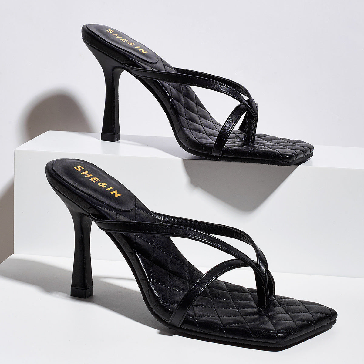 Black square-toe sculpted strap mule heels shown as a pair