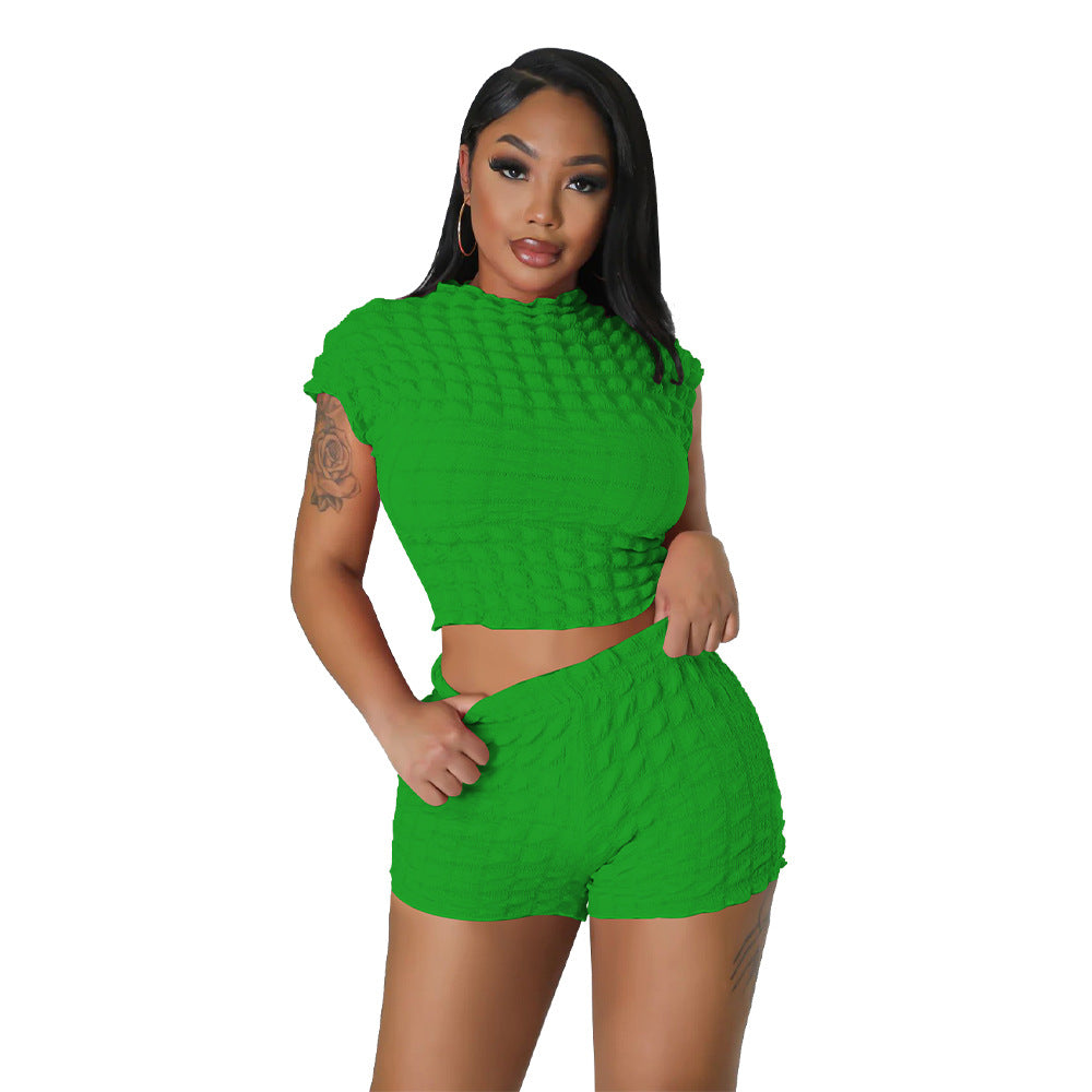 Adult model wearing the dark-green bubble-texture crop top and matching shorts, front cutout view.