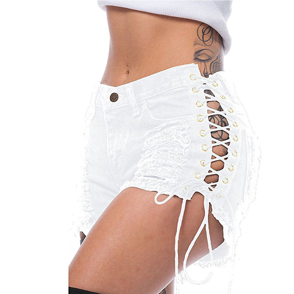 Close side-front view of white distressed lace-up cutout shorts on an adult model.