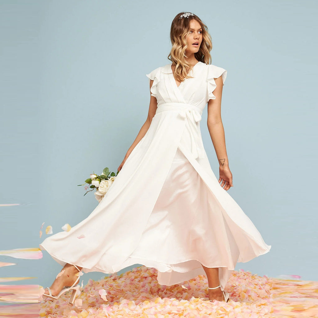 Petal Waltz white maxi dress showing tie waist, wrap-effect front, and flowing hem