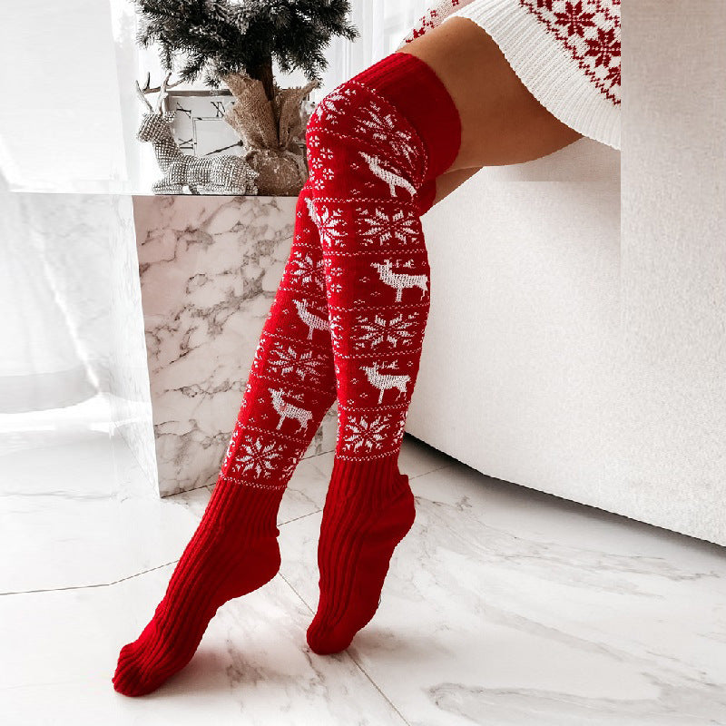Red acrylic knit over-the-knee stockings with white reindeer and snowflake pattern.