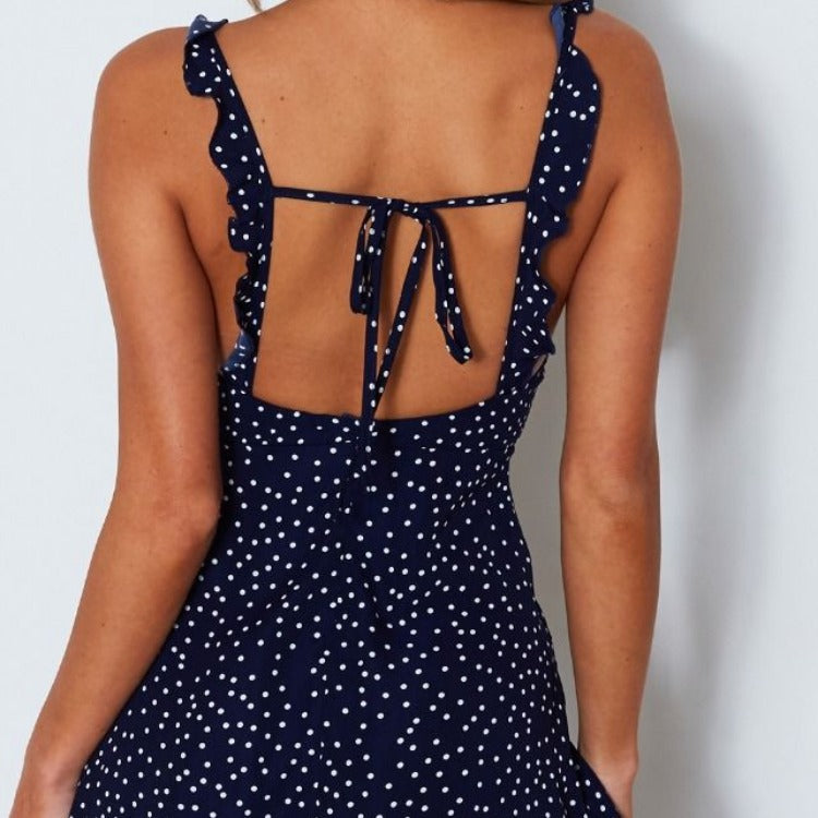 Back view of the dark blue dotted sundress showing ruffled straps and the open tie back.