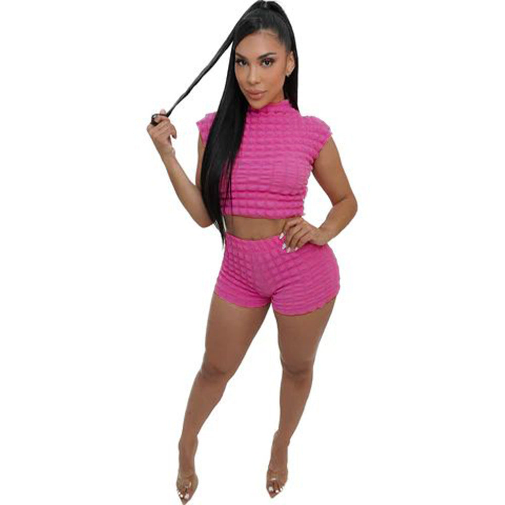 Adult model wearing the rose-red bubble-texture crop top and matching shorts, full front view.