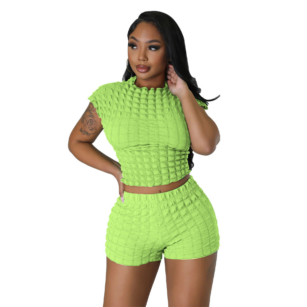 Adult model wearing the light-green bubble-texture crop top and matching shorts, front view.