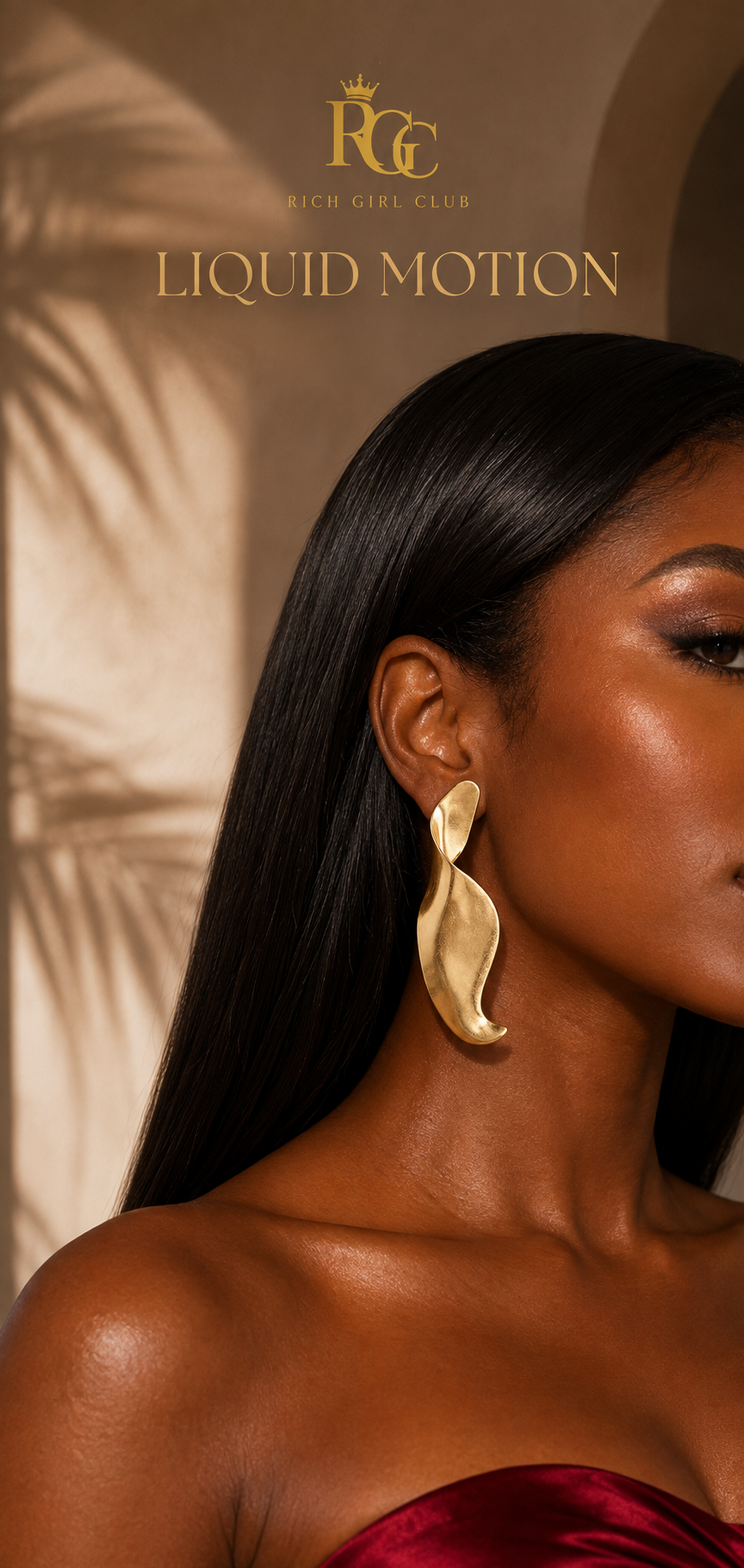 Adult model wearing the gold Liquid Motion sculptural swirl earring in a warm Rich Girl Club studio