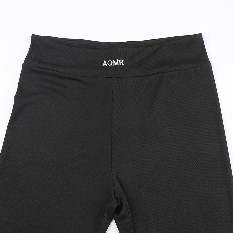 Close-up of black pants waistband with embroidered AOMR mark