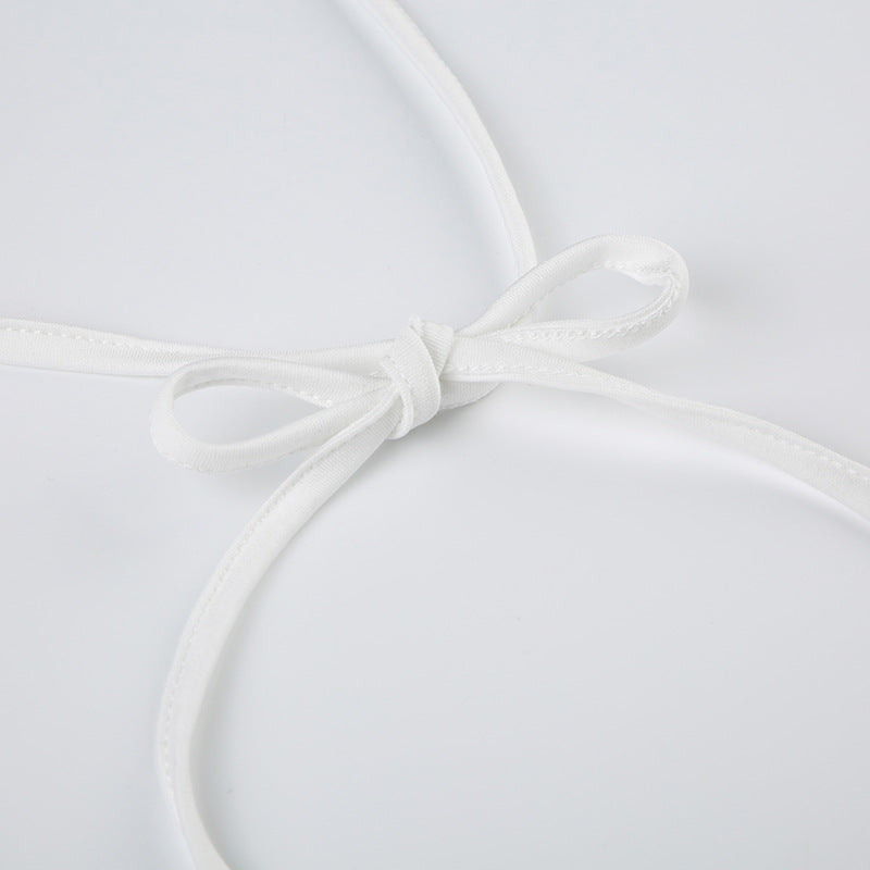 Close-up of white halter tie straps knotted in a bow