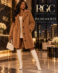 Adult model wearing the camel Plush Society Longline Jacket in a luxury penthouse campaign.