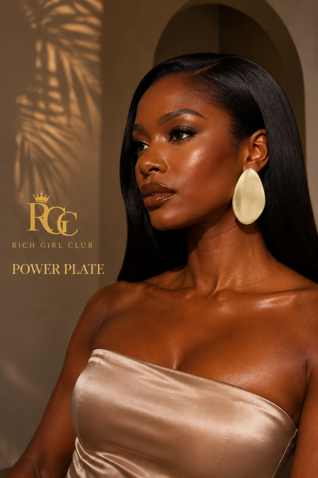 Adult model wearing the gold Power Plate statement earring in a warm Rich Girl Club studio