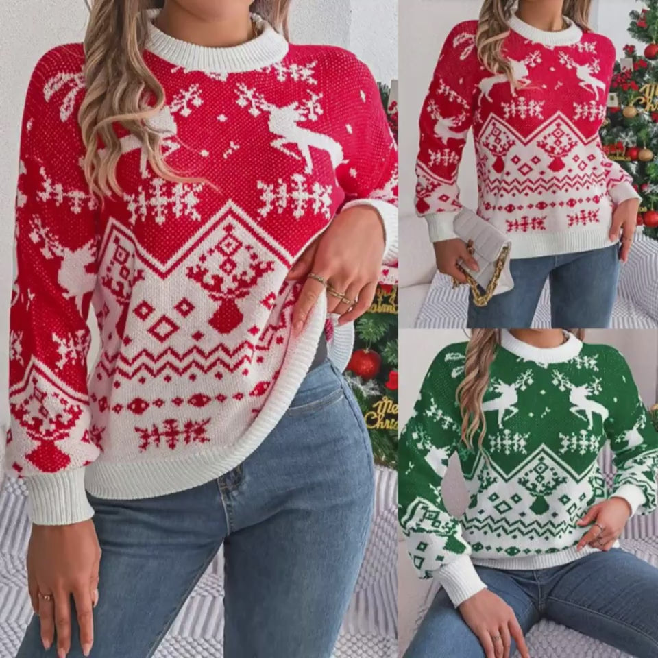 Adult model wearing the red and white Merry Main Character Reindeer Sweater with jeans beside a decorated Christmas tree, showing the crew neck, long sleeves, reindeer-and-snowflake knit pattern, and white ribbed trim.